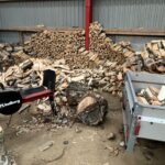 Birkebrænde bliver kløvet og stablet i stålladen på ejendommen.