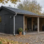 Illustration af velholdt mørkt træskur med carport i efterårshave, rene tagrender og tørt opbevaret haveværktøj.